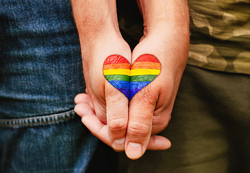 Image of hands with a panted rainbow heart on them.