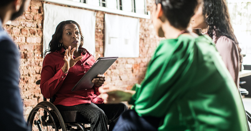 image of woman in a wheelchair talking to coworkers