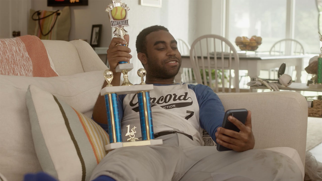 man on couch with trophy