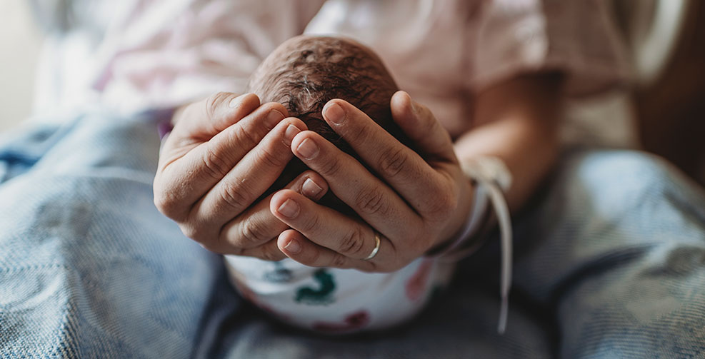 woman holding newborn in hospital
