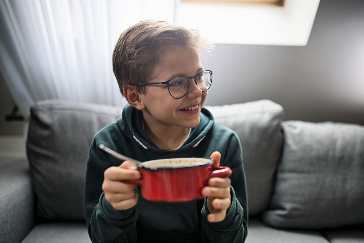 young boy eating a bowl of chili