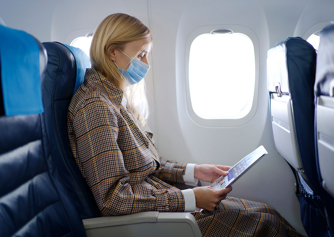 woman wearing a mask on an airplane
