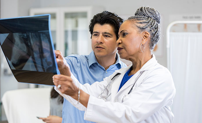 provider looking at an X-ray with patient