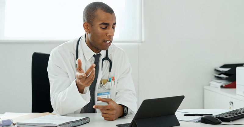 physician on laptop talking to a patient