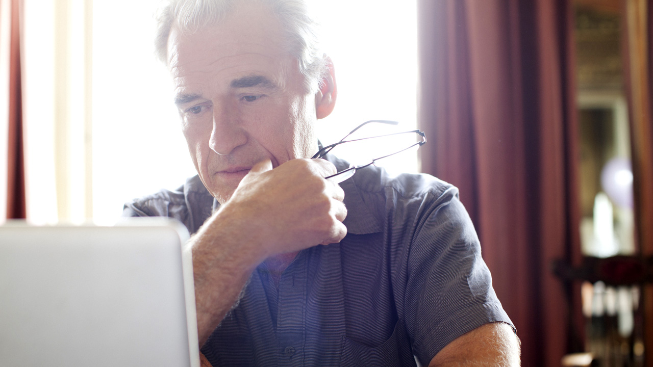 older man on his laptop at home