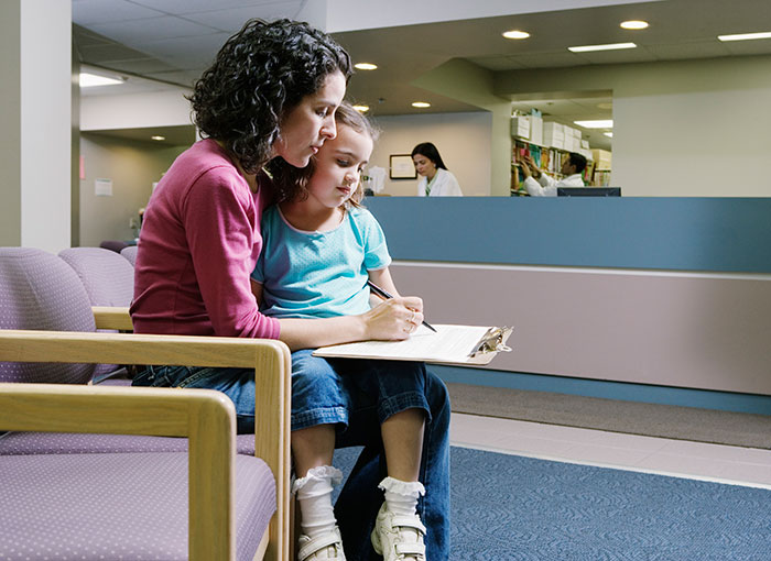 Mother and Daughter in a waiting room - Tufts Health RITogether.