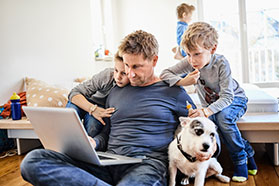 dad at home with kids on laptop