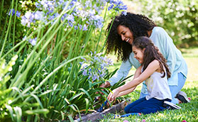 mom planting flowers with daughter